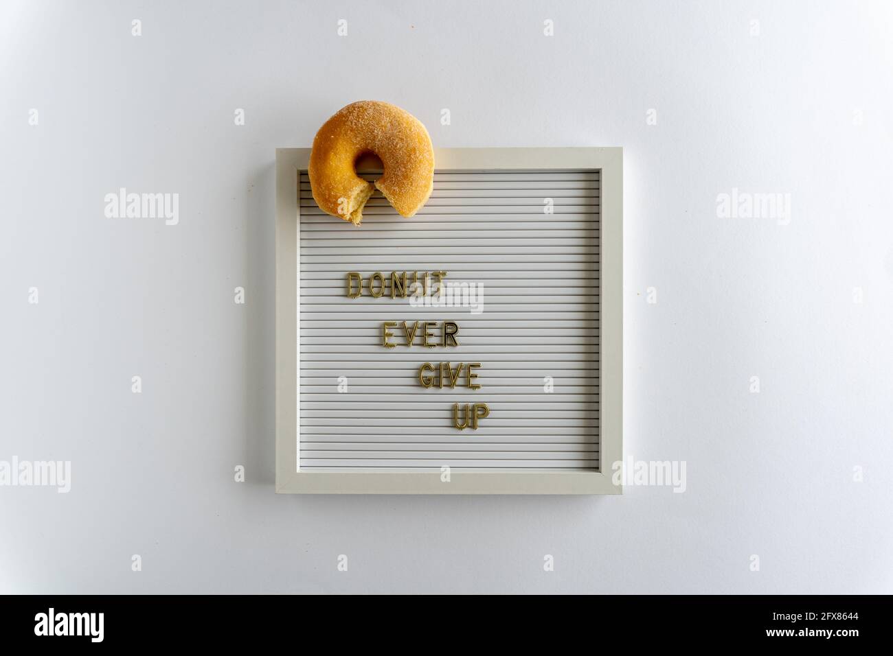 Letterboard With Words That Spell Donut Ever Give Up In Golden Letters On A White kground Horizontal Stock Photo Alamy
