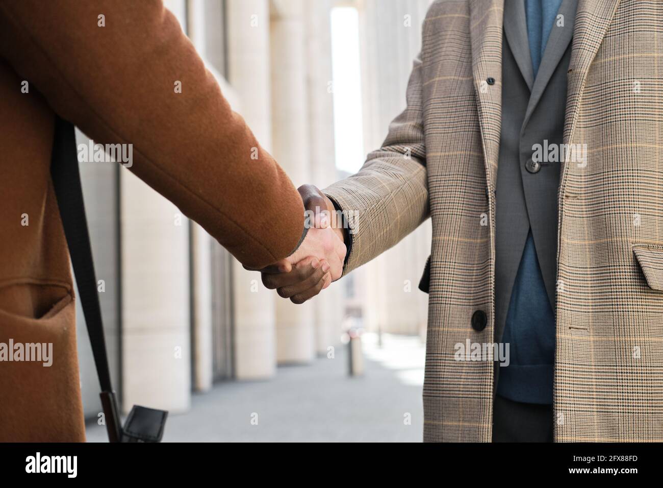 Close-up of business people shaking hands at meeting at the city Stock Photo