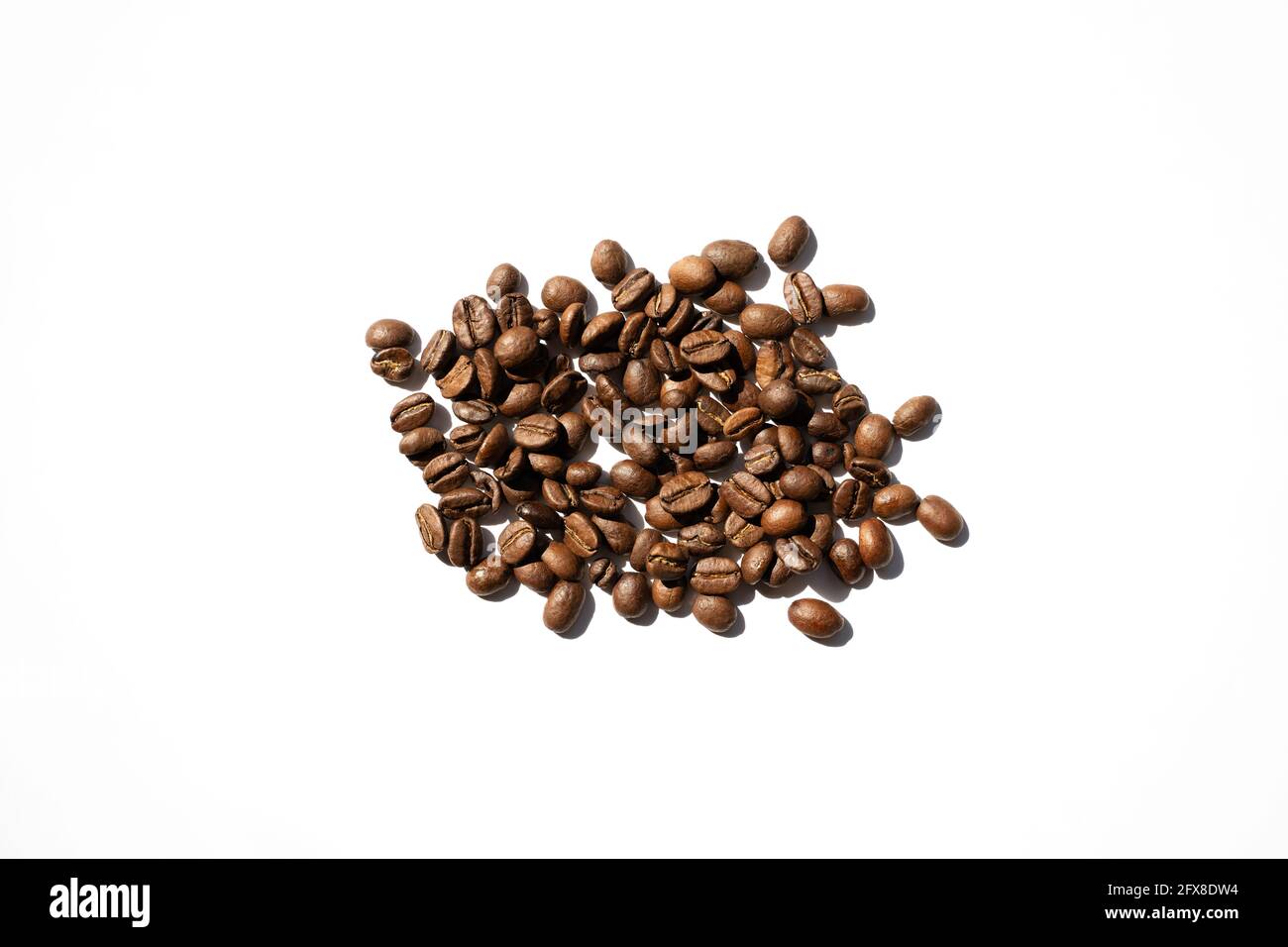 Isolated roasted coffee beans in harsh light. White background top view ...