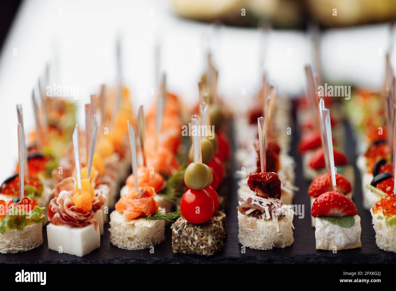 Delicious appetizers and canapes on table at wedding reception in the  restaurant. Luxury catering service. Italian delicatessen, prosciutto  snacks Stock Photo - Alamy