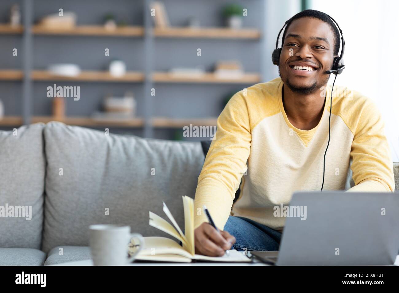 Joyful black guy having online class at home Stock Photo