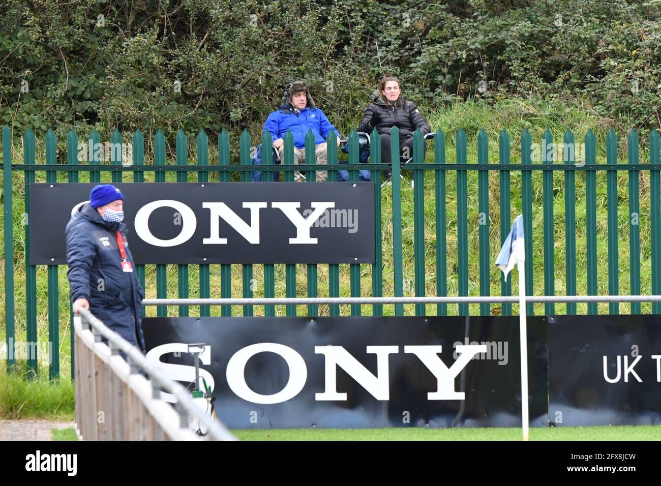Bridgend, Wales. 10 October, 2020. Fans sit outside the stadium perimeter fence to watch the JD Cymru Premier match between Penybont and The New Saints at the SDM Glass Stadium in Bridgend, Wales, UK on 10, October 2020. Sporting stadiums around the UK remain under strict restrictions due to the Coronavirus Pandemic as Government social distancing laws prohibit fans inside venues resulting in games being played behind closed doors. Credit: Duncan Thomas/Majestic Media. Stock Photo