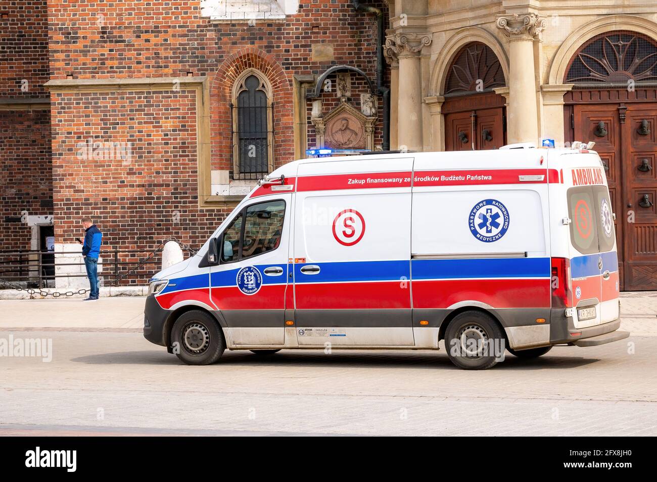 Krakow, Poland, Polish ambulance with sirens on moving, driving through the Cracow Main Market Square, emergency vehicle closeup, medical transportati Stock Photo