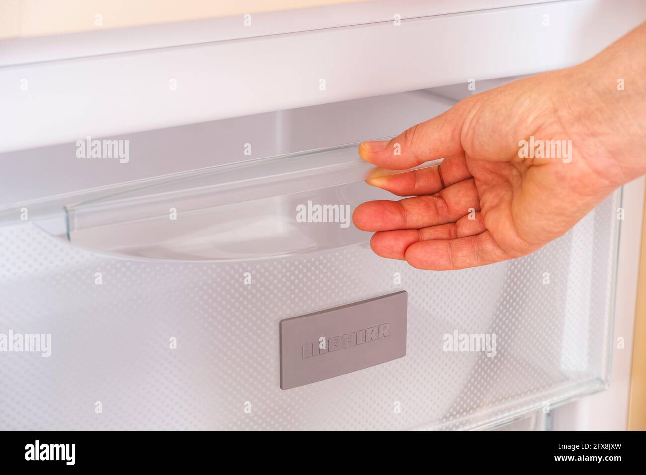 Tambov, Russian Federation - April 15, 2021 A woman's hand taking a compartment out of a Liebherr fridge. Stock Photo