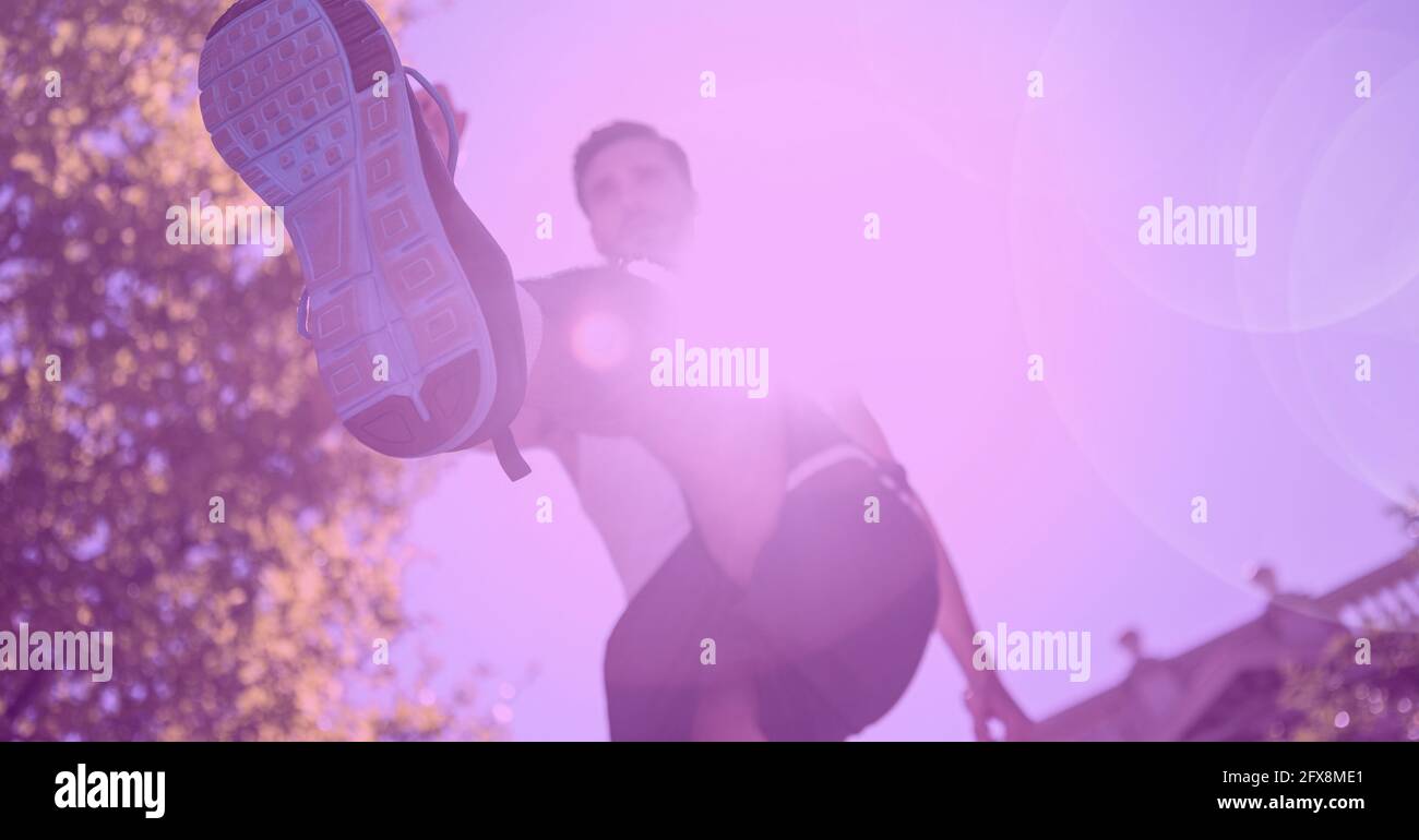 Composition of man running with glowing light and pink tint Stock Photo