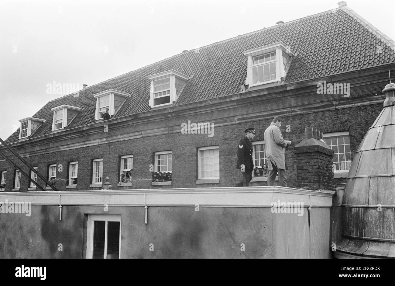 Occupation Maagdenhuis Amsterdam, by students police on roof Maagdenhuis, from windows look occupiers, may 20, 1969, POLICE, occupations, students, The Netherlands, 20th century press agency photo, news to remember, documentary, historic photography 1945-1990, visual stories, human history of the Twentieth Century, capturing moments in time Stock Photo