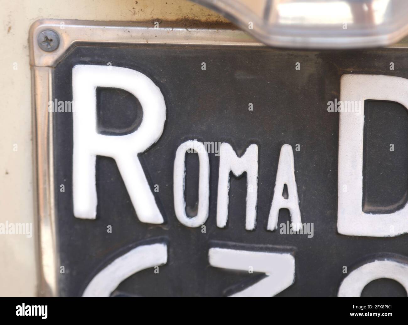 large text ROMA on an old license plate of a car in the capital city of