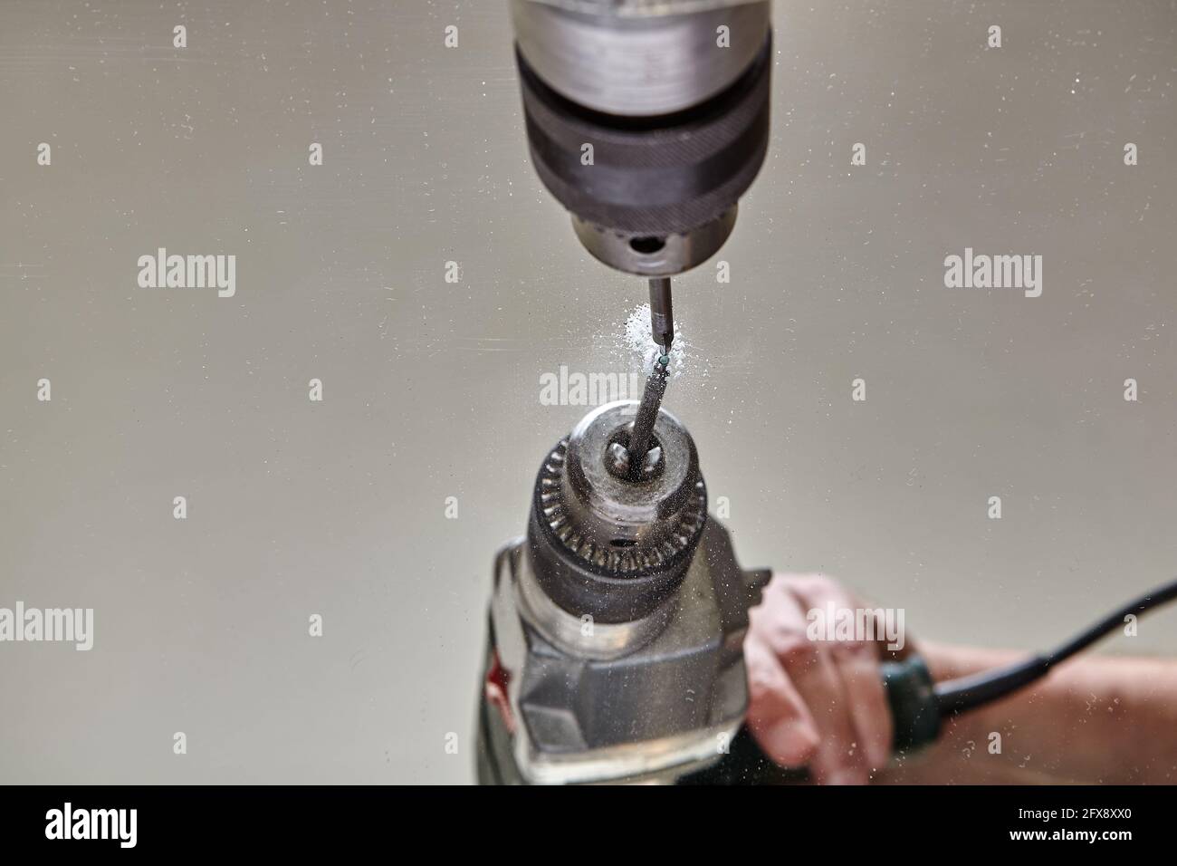 Drilling hole in glass or mirror with special drill bit. Stock Photo
