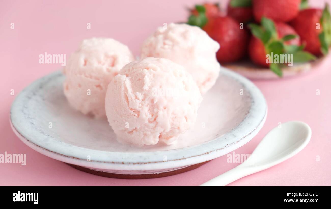 Strawberry ice cream scoops on a plate. Homemade pink strawberry ice cream, italian gelato Stock Photo