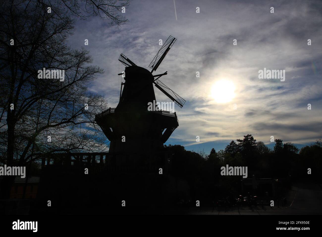 Silhouette of an old windmill made of wood . Stock Photo
