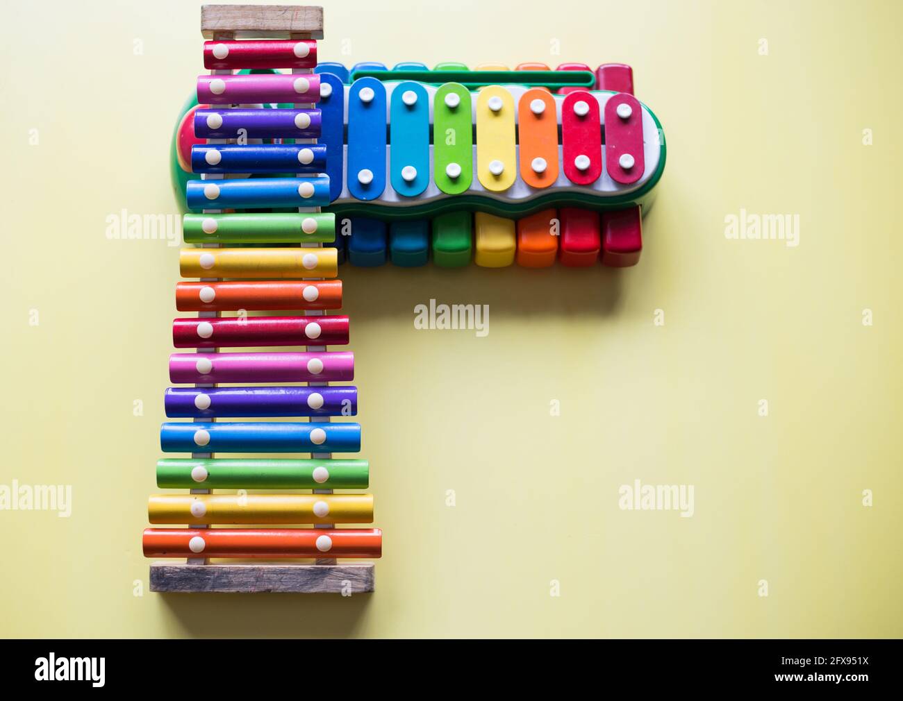 Overhead shot of toy xylophones music equipment on a yellow surface