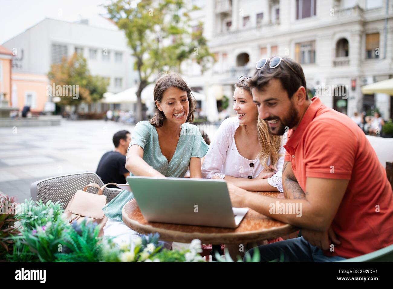Friends at cafe talking laughing and enjoying their time using digital tablet. Stock Photo
