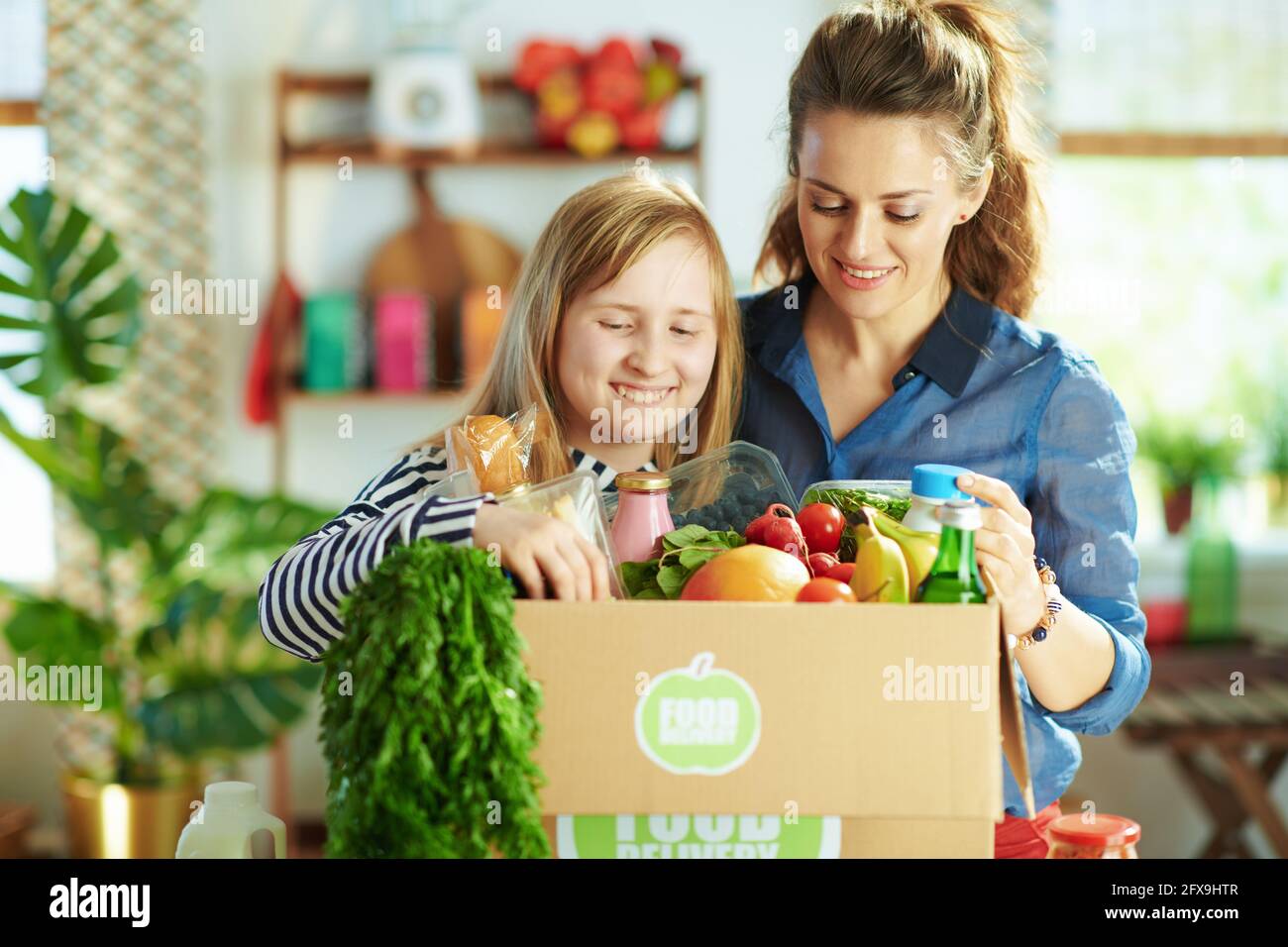 Food delivery. happy modern mother and daughter with food box in the