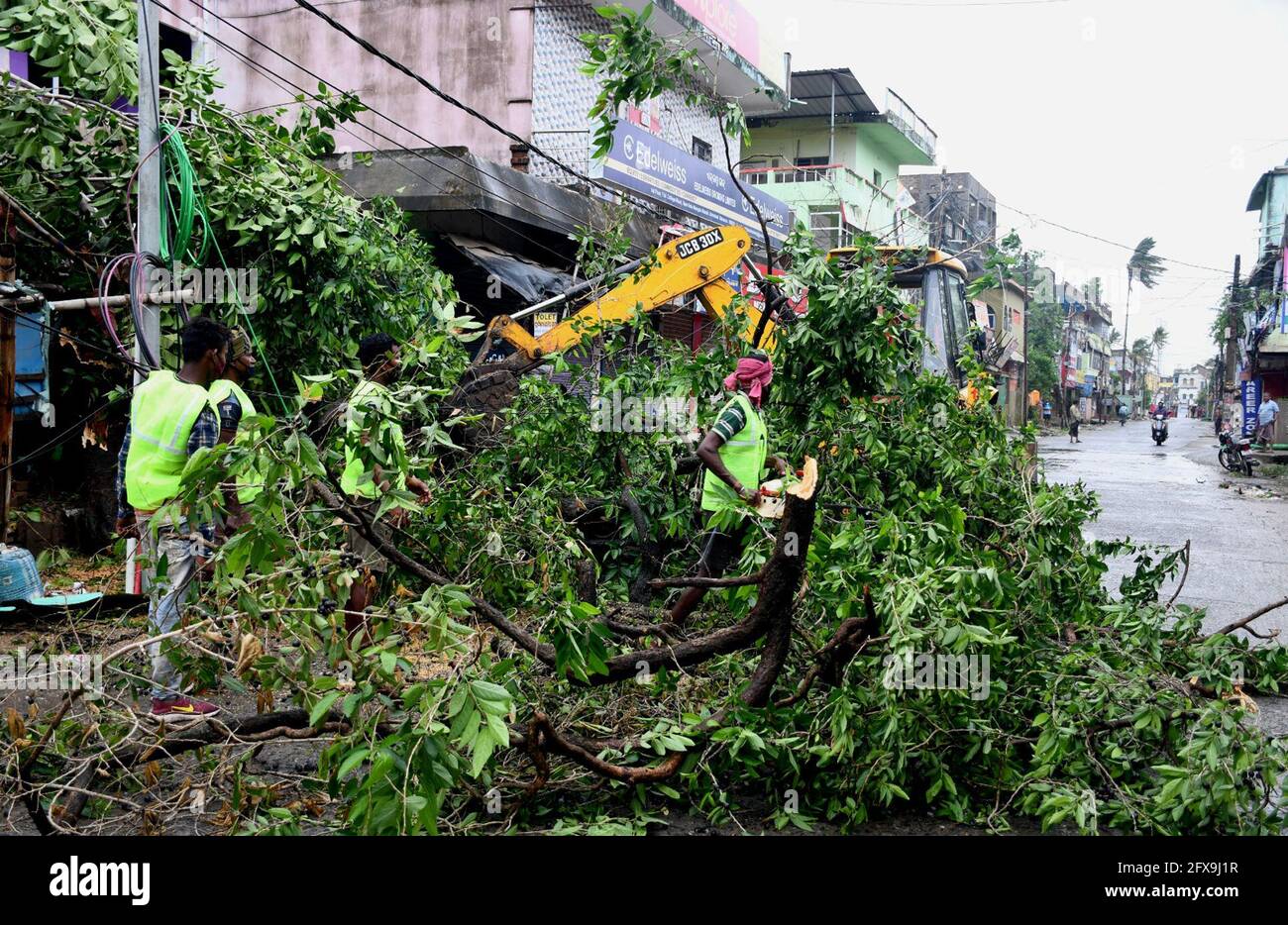 Balasore. 26th May, 2021. Municipal workers remove an uprooted tree from a road after cyclonic storm Yaas hit Balasore district of Odisha on May 26, 2021. Five people were killed on Wednesday after cyclonic storm Yaas hit the coastal area of the eastern Indian states of West Bengal and Odisha, local media reported. Credit: Str/Xinhua/Alamy Live News Stock Photo