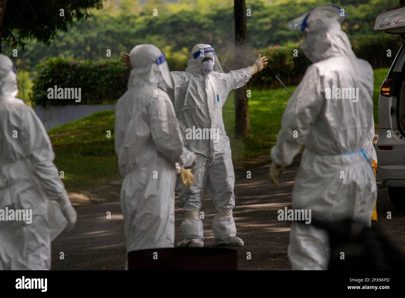 Semenyih, Malaysia. 26th May, 2021. People in protective suits disinfect themselves after burying a COVID-19 victim at a graveyard in Semenyih, Selangor, Malaysia, May 26, 2021. Malaysia on Wednesday reported the highest daily spike of new confirmed COVID-19 cases and deaths since the start of the pandemic, the Health Ministry said. As many as 7,478 new COVID-19 infections were reported, bringing the national total to 533,367. Another 63 deaths have been reported, the highest in a single day, pushing the total deaths to 2,432. Credit: Chong Voon Chung/Xinhua/Alamy Live News Stock Photo