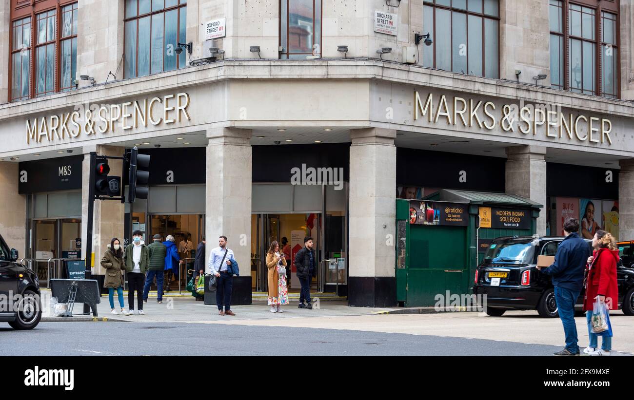 London, UK.  26 May 2021.  People pass the exterior of Marks & Spencer’s flagship store on Oxford Street.  The company has reported losses of £201.2m and announced plans to recover from the effect of high street store closures lockdowns by shutting stores and increasing online grocery sales.   Credit: Stephen Chung / Alamy Live News Stock Photo