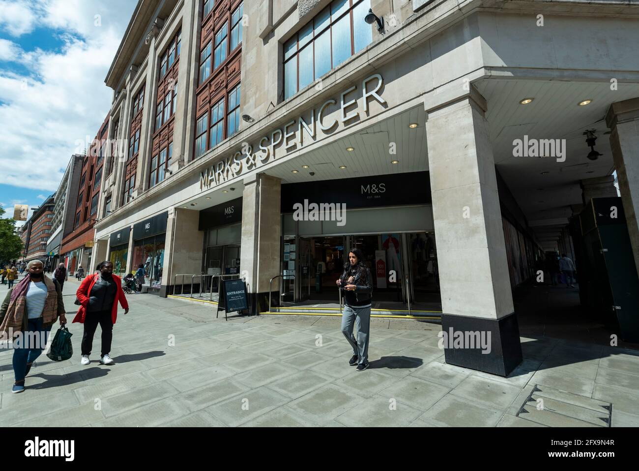 London, UK.  26 May 2021.  People pass the exterior of Marks & Spencer’s flagship store on Oxford Street.  The company has reported losses of £201.2m and announced plans to recover from the effect of high street store closures lockdowns by shutting stores and increasing online grocery sales.   Credit: Stephen Chung / Alamy Live News Stock Photo