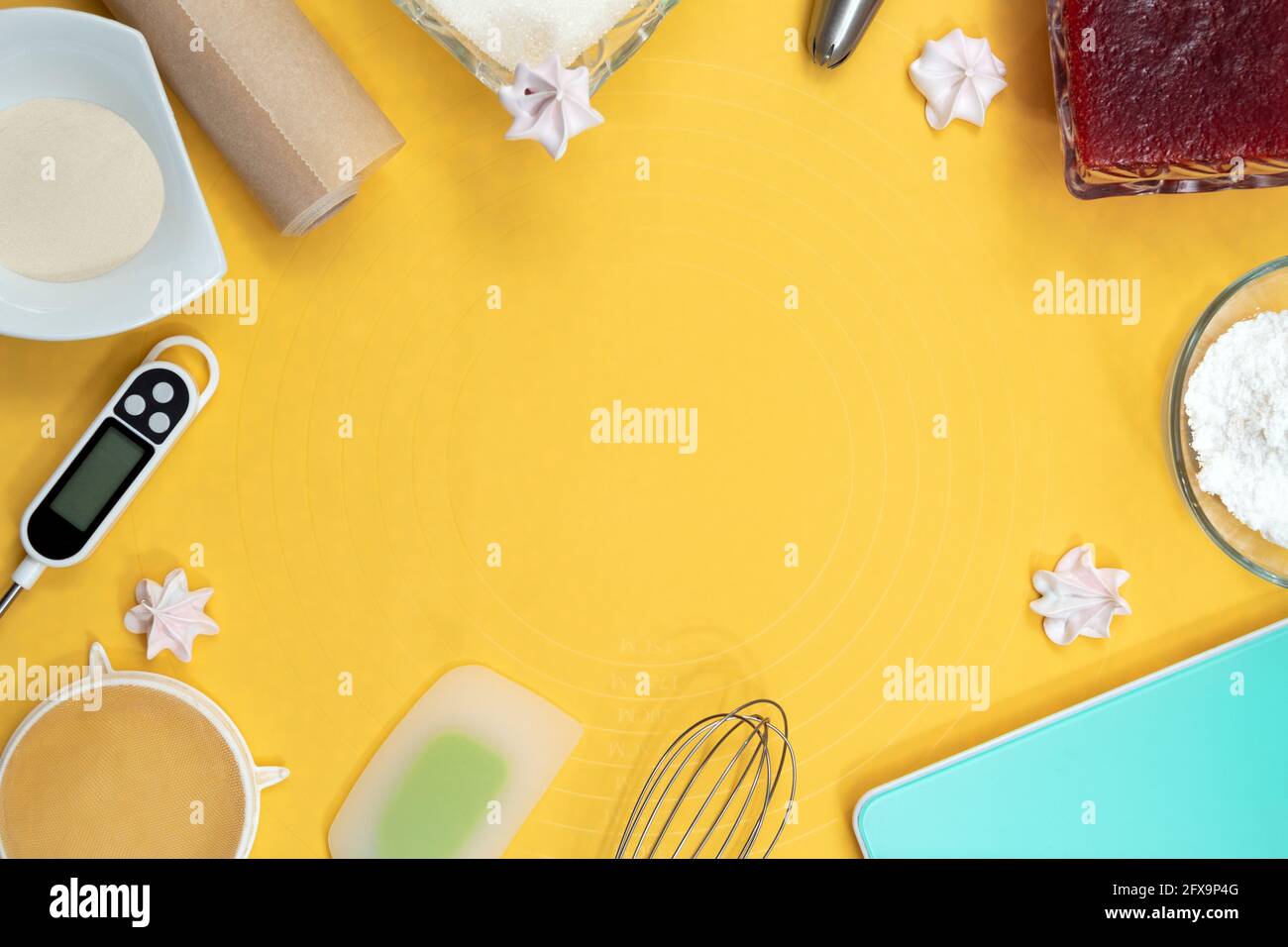 Tools and ingredients for making meringue: thermometer, whisk, spatula, parchment, sugar, jam, metal nozzle. Top view. Yellow background with space Stock Photo