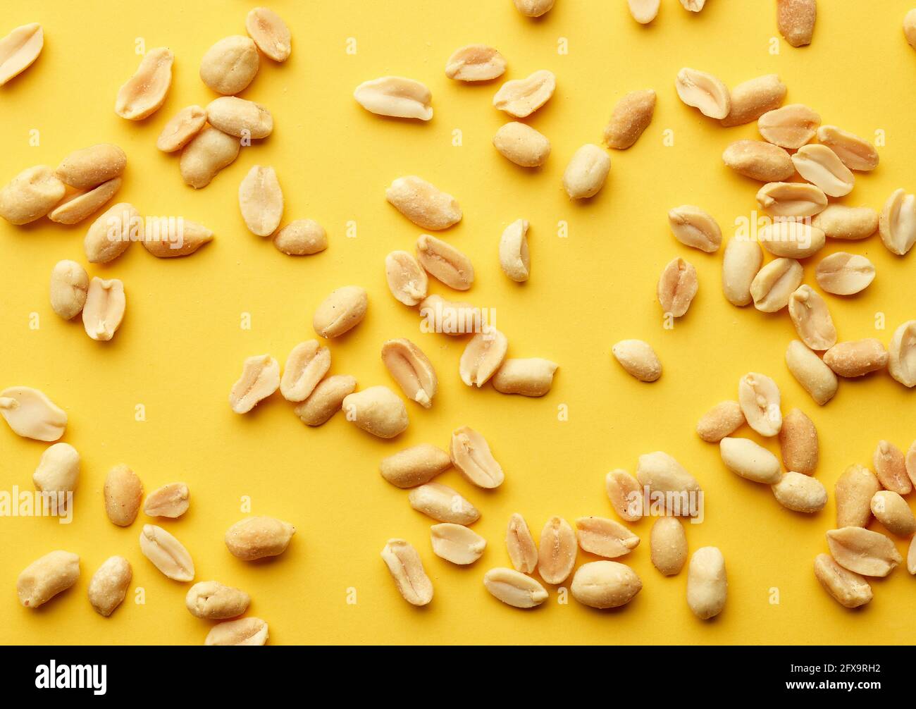 roasted salted peanuts on yellow background, top view Stock Photo