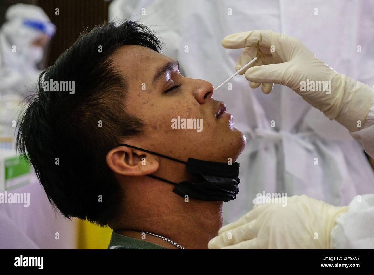 Sungai Buloh, Malaysia. 26th May, 2021. A man is seen getting a nasal swab sample during the COVID19 testing at a test center in Sungai Buloh. Malaysia has recorded the highest daily cases of Covid-19, yesterday with a record of 7,289 cases. Selangor government continues to conduct mass COVID19 screening tests over the state to battle the coronavirus pandemic. (Photo by Faris Hadziq/SOPA Images/Sipa USA) Credit: Sipa USA/Alamy Live News Stock Photo