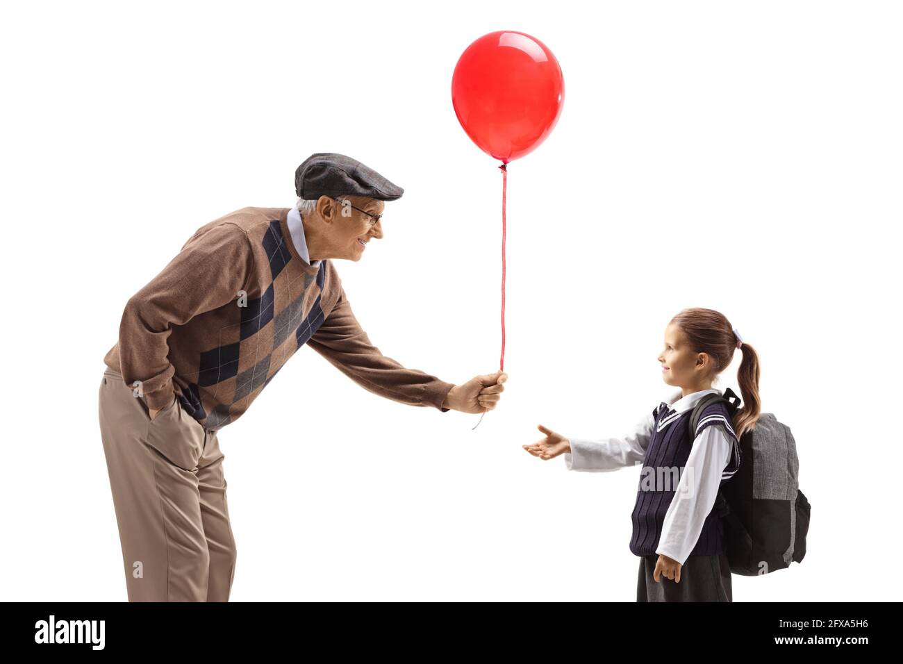Grandfather giving a red balloon to a schoolgirl isolated on white background Stock Photo