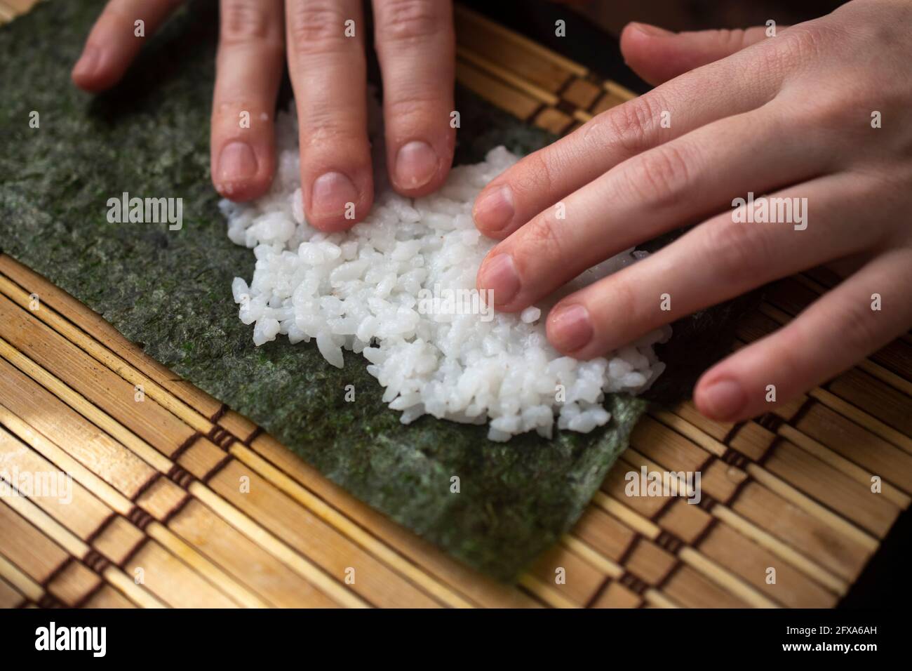 hands twist sushi rolls. close-up. japanese cuisine cooking method ...