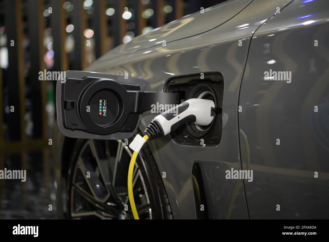 Power cable plug in charging power to electric vehicle EV car, alternative sustainable eco energy. Stock Photo