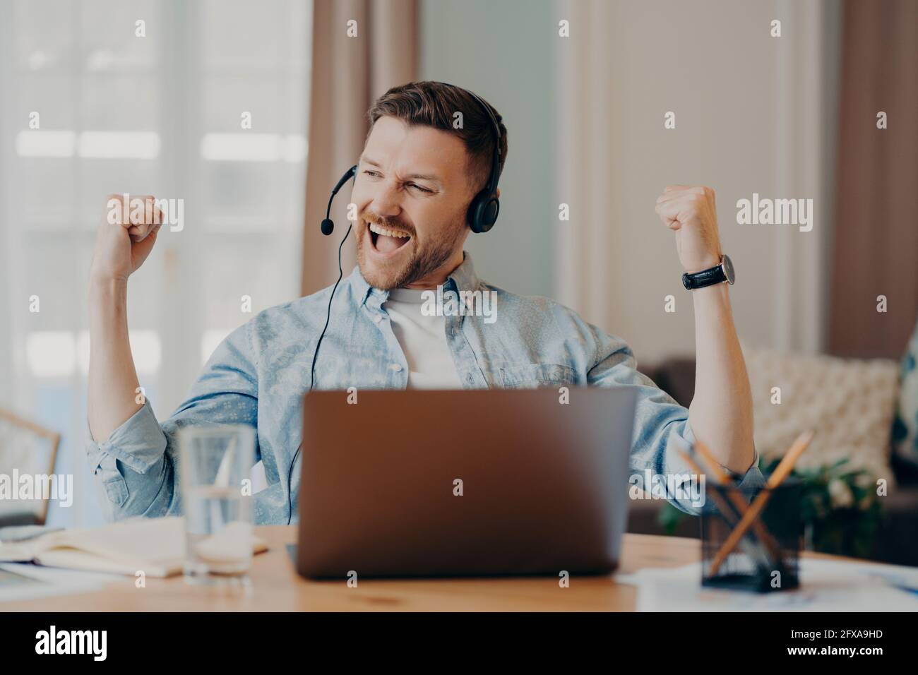Caucasian bearded guy enjoying successful negotiations online Stock Photo