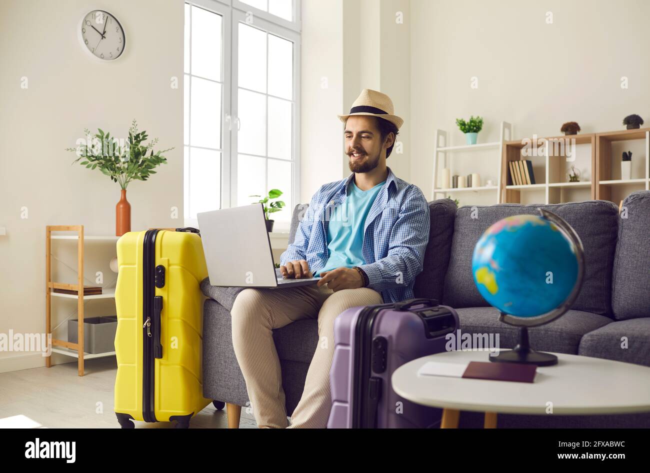 Young man planning holiday trip and using laptop to look for rentals or book hotel room Stock Photo