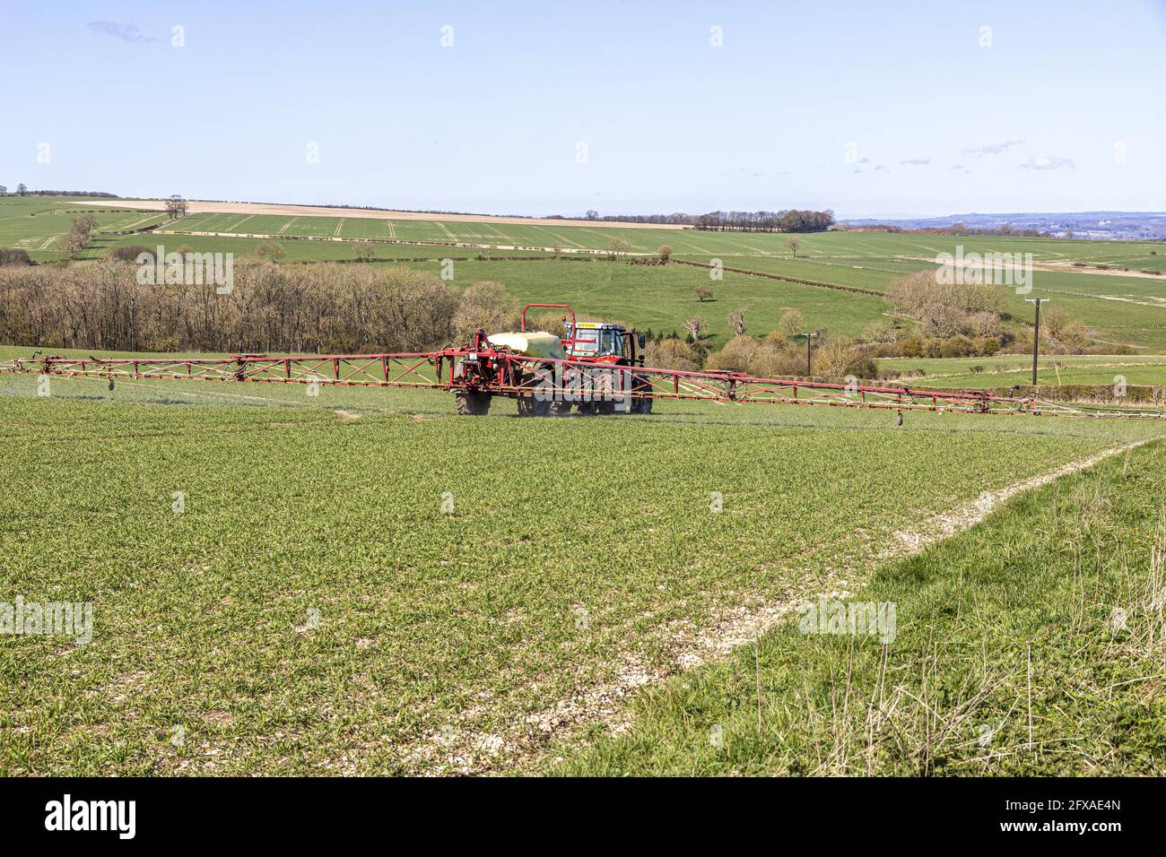 A tractor crop spraying on the Yorkshire Wolds near Wharram le Street, North Yorkshire, England UK Stock Photo