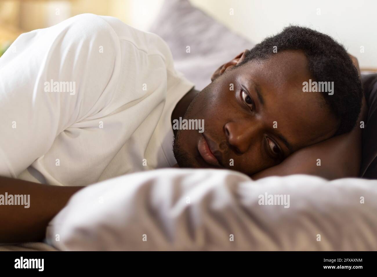 African tired man cannot sleep from insomnia Stock Photo