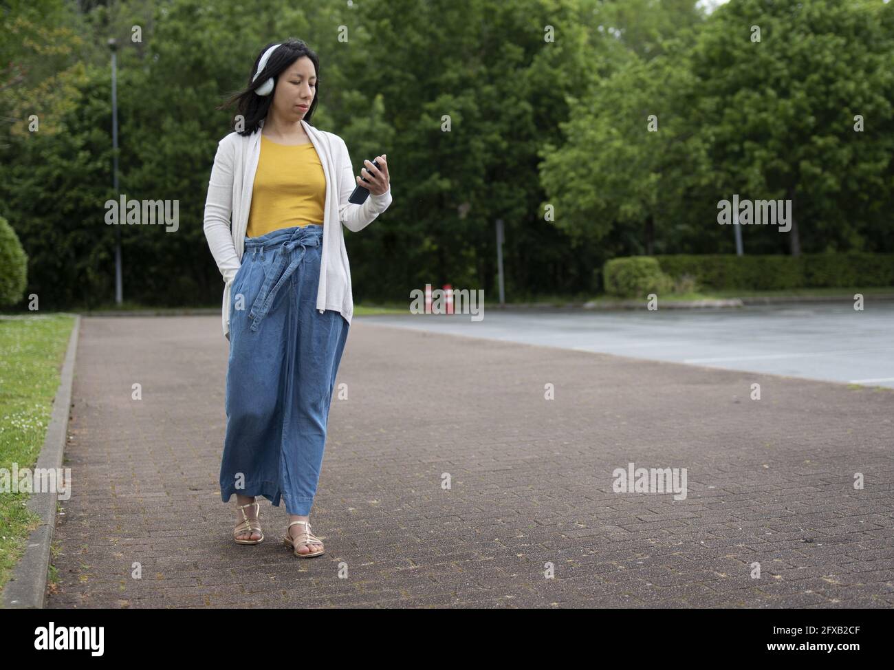 Young Hispanic female listening to music on her headphones Stock Photo ...