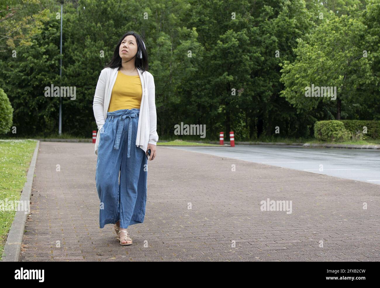 Young Hispanic female listening to music on her headphones Stock Photo ...