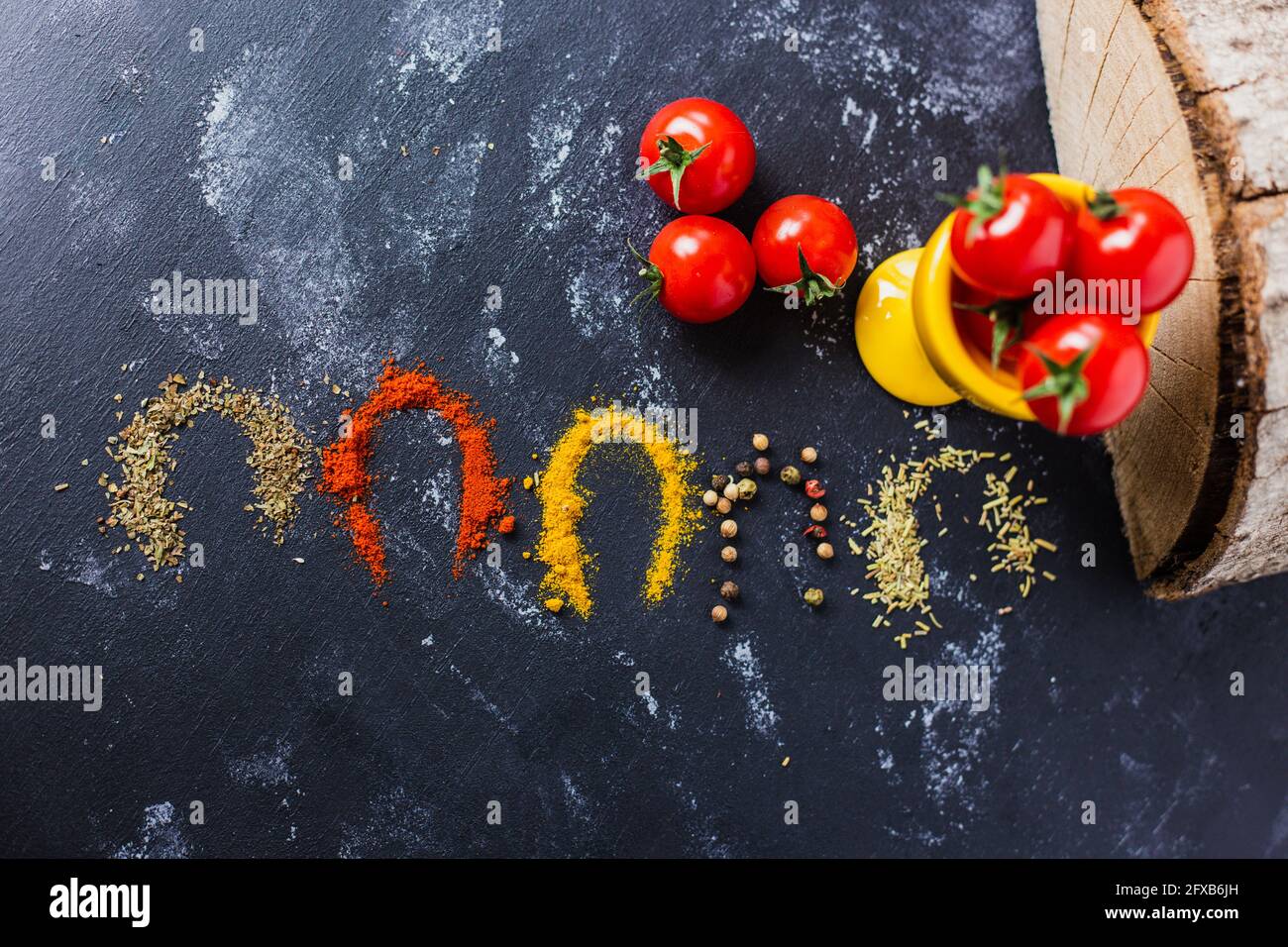 Top view of colorful spices and cherry tomatoes on the table Stock Photo