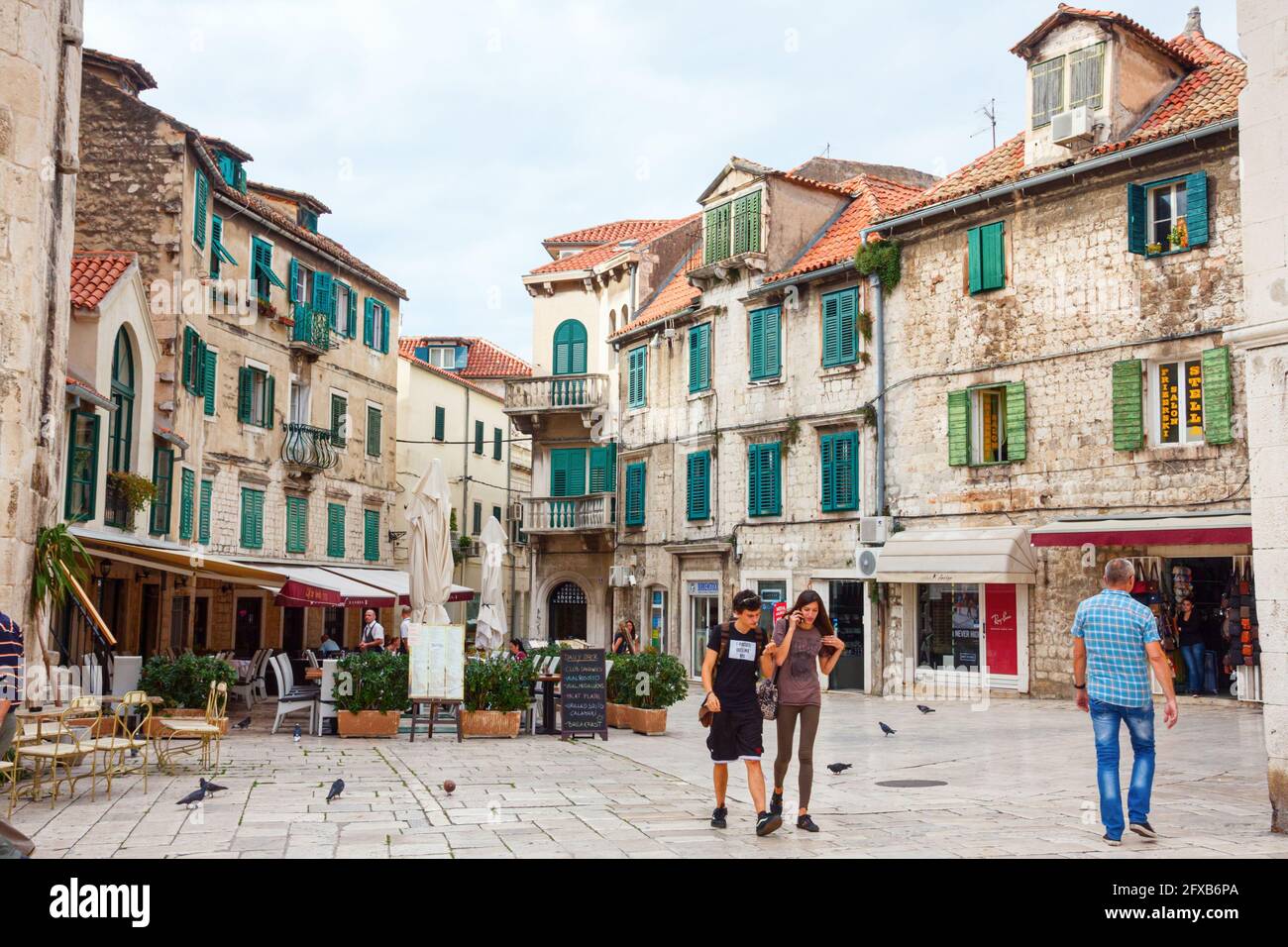 SPLIT, CROATIA - OCTOBER 10, 2014: Tourists walking along the square Trg Brace Radic with old medieval houses in the background. Split is a major tour Stock Photo