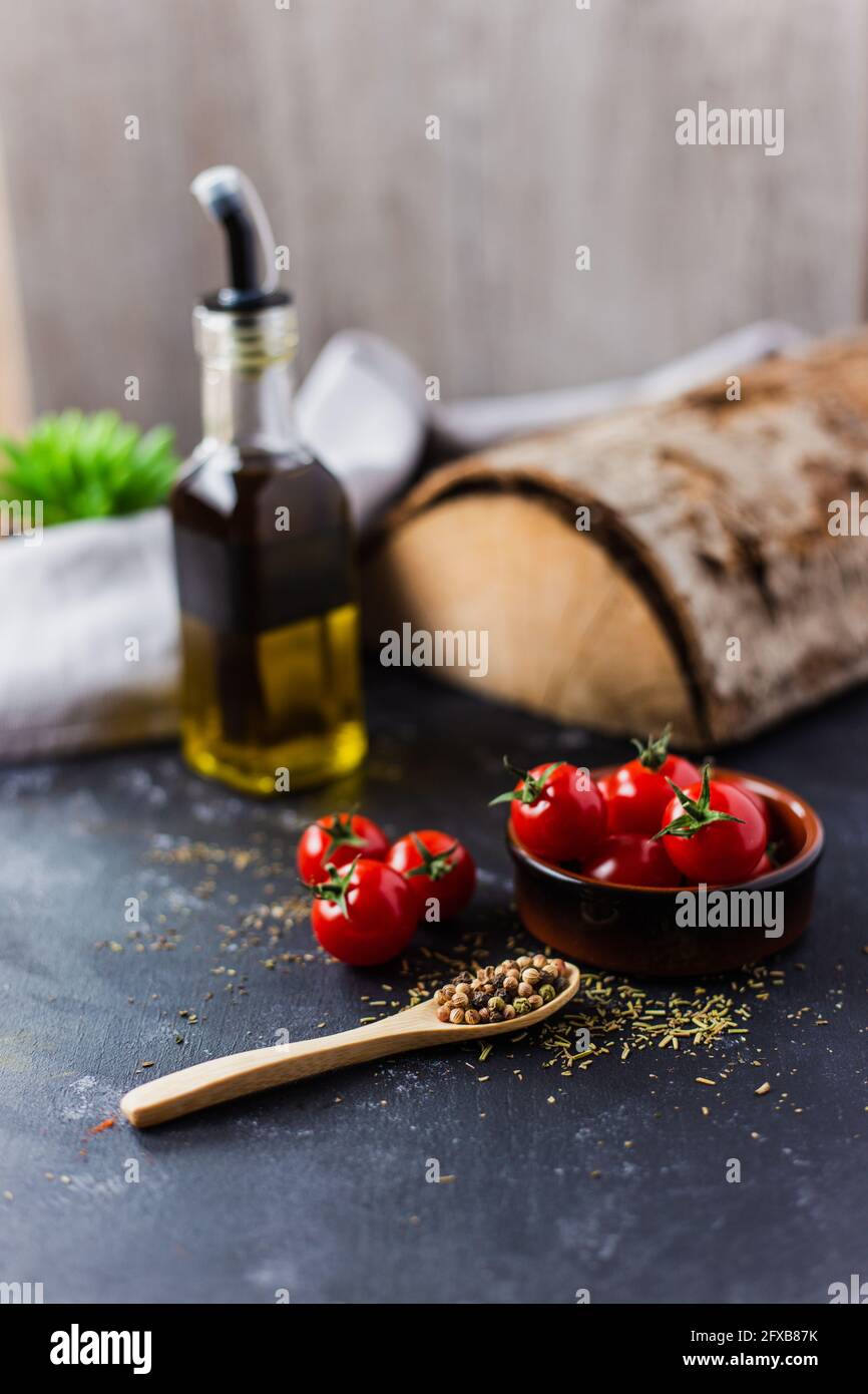 Spoons with spices, paprika, basilic, pepper, thyme with cherry tomatoes Stock Photo
