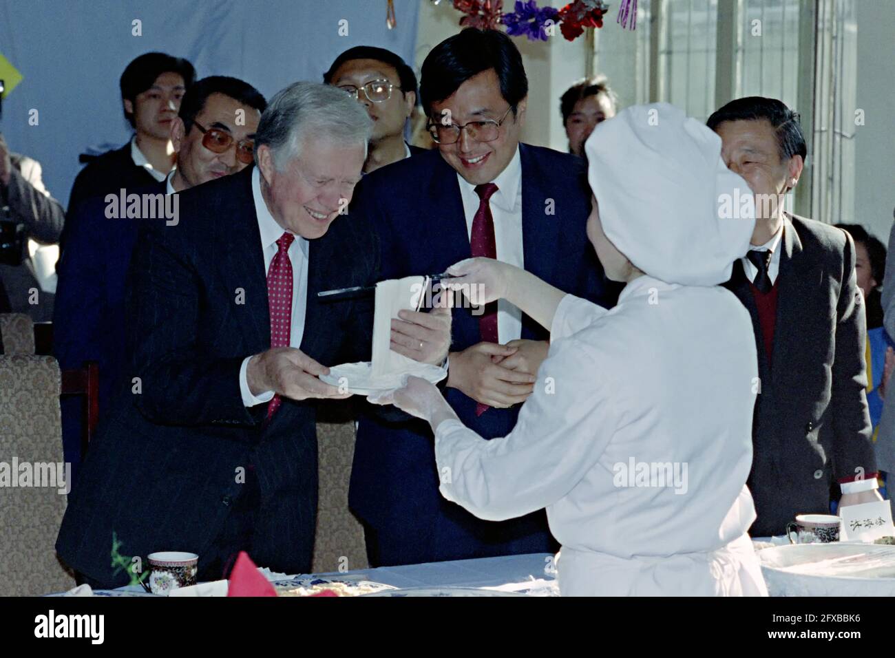 Former U.S. President Jimmy Carter smiles as he is show homemade noodles during a visit to a school for the deaf April 14, 1991 in Beijing, China. The former president funded programs to train special education instructors in China in 1987 and was checking on the progress of his program. Stock Photo