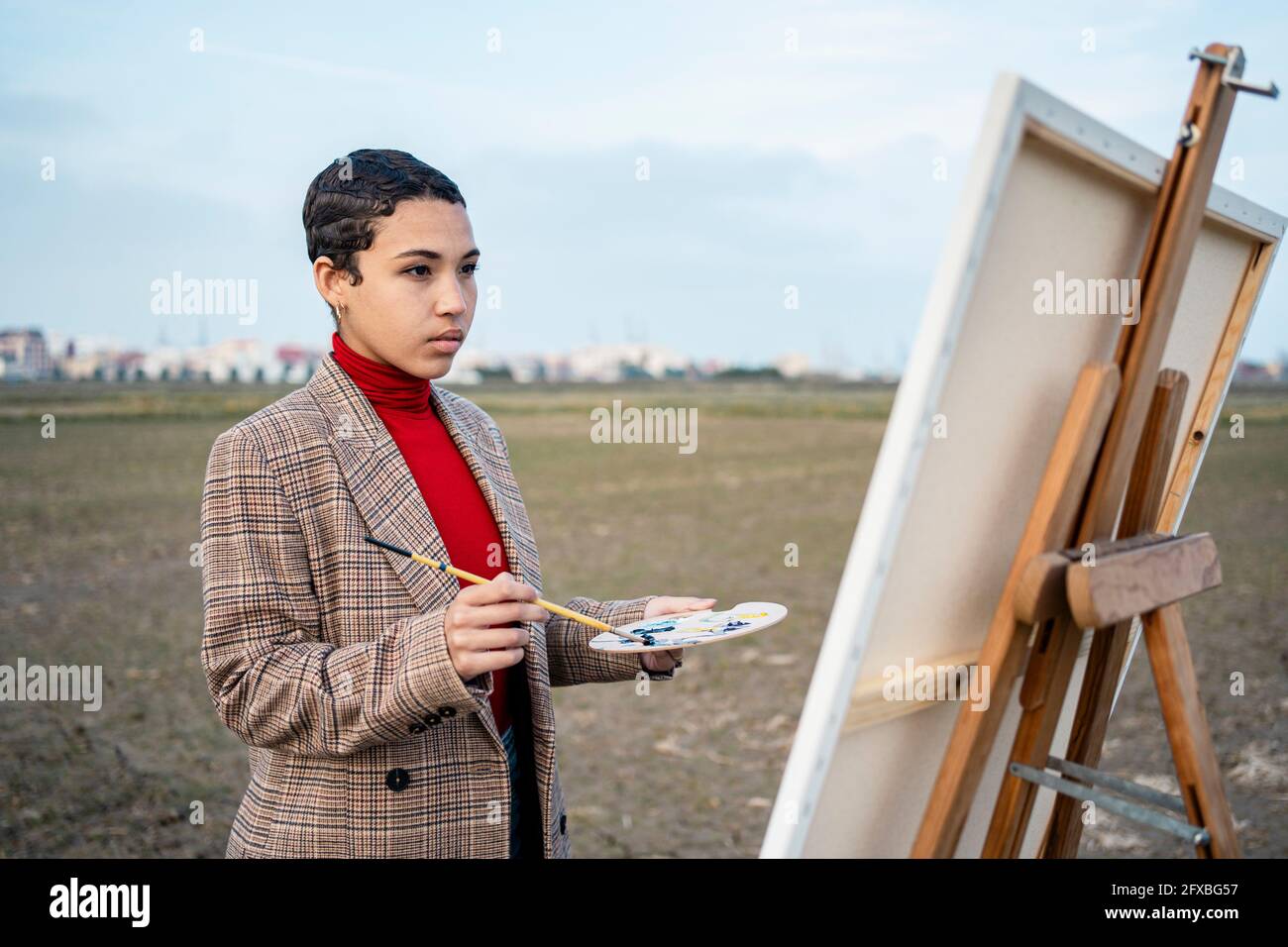 Woman looking at painting at countryside. Stock Photo