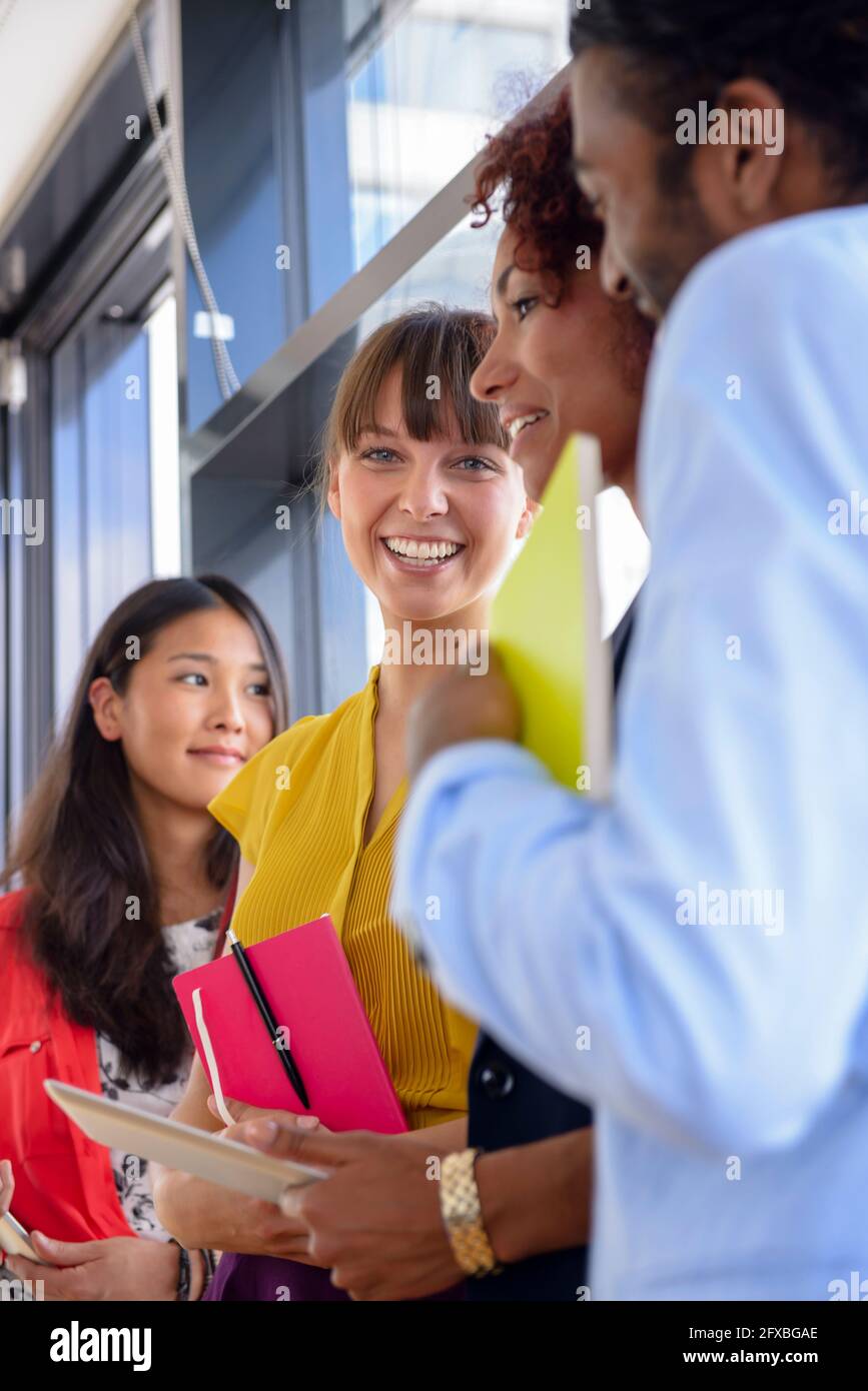 Cheerful businesswoman amidst multi-ethnic colleagues at office Stock Photo