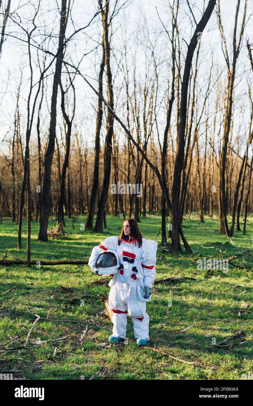 Female astronaut with space helmet standing in forest Stock Photo - Alamy