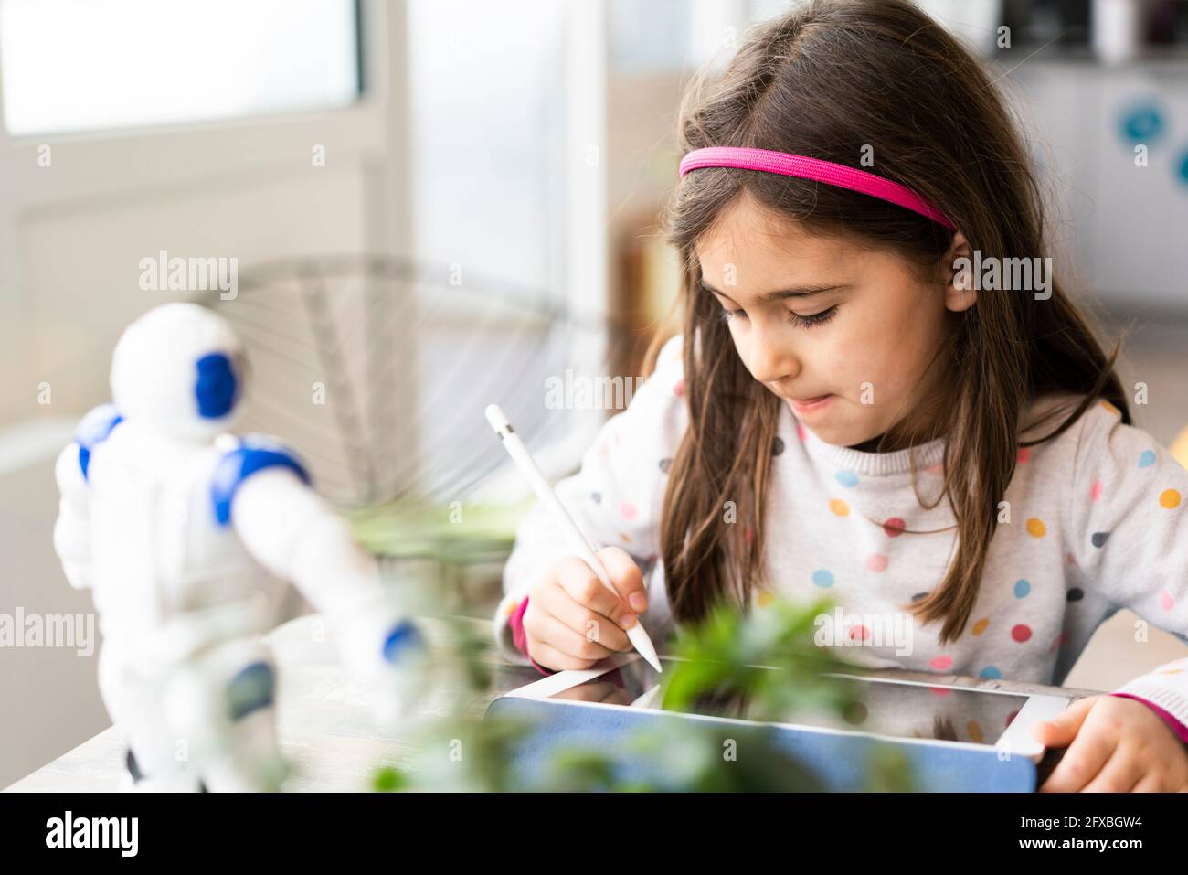 Girl using digital tablet while studying at home Stock Photo