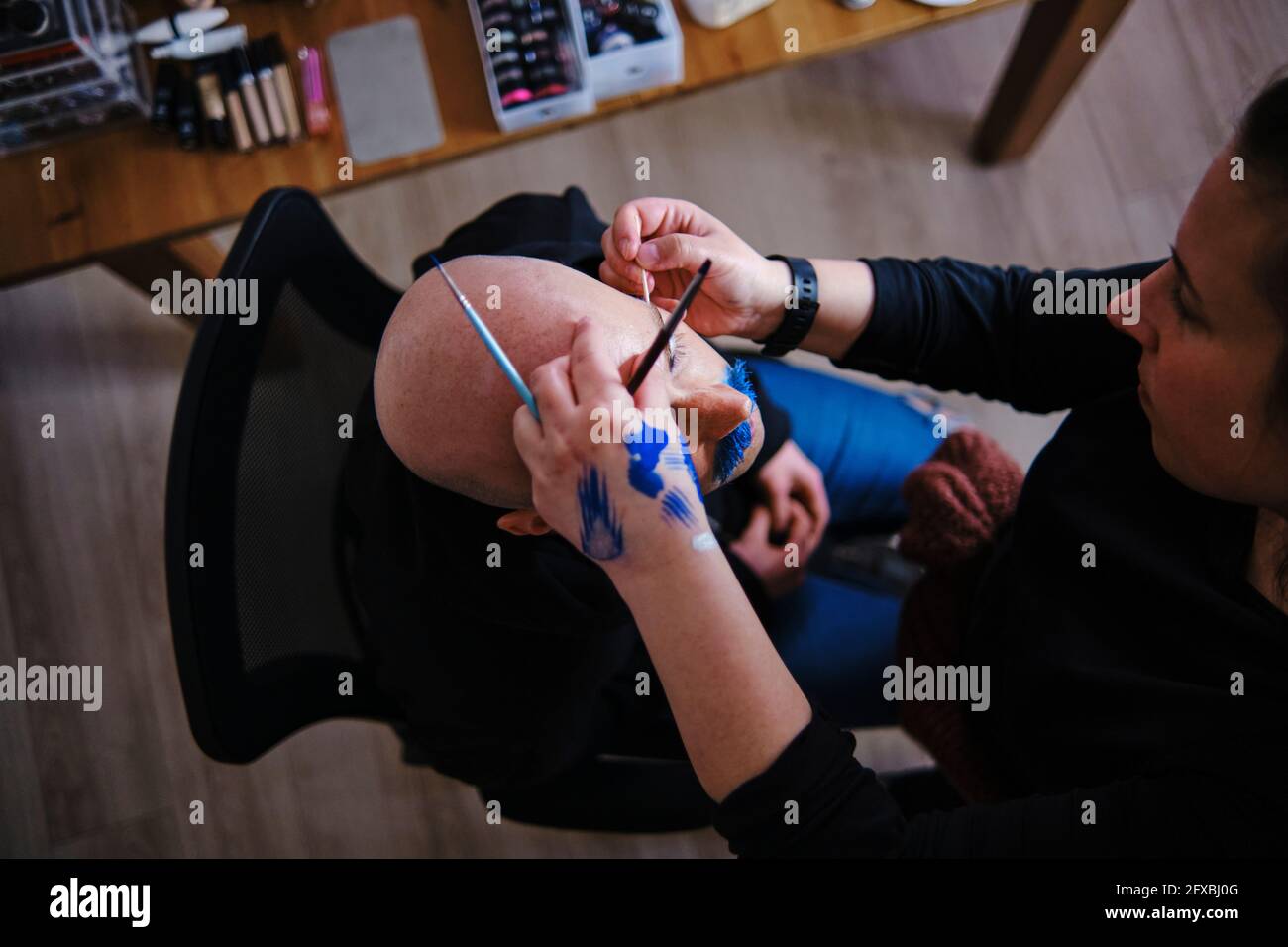 Make-up artist working on model in studio Stock Photo