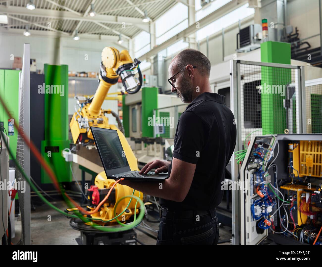 Male Engineer using laptop in industry Stock Photo