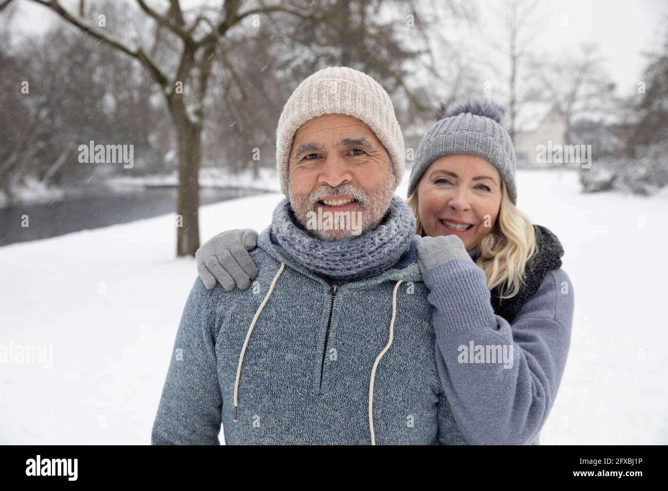 Smiling woman in warm clothing standing with man at park Stock Photo