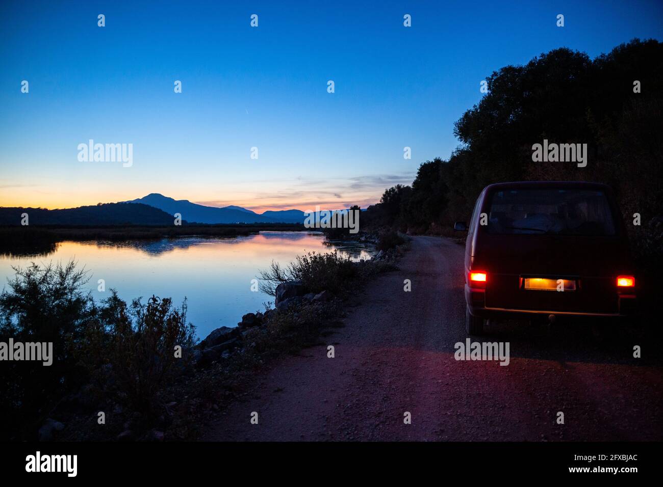 Van driving along dirt road in Amvrakikos Wetlands National Park at dusk Stock Photo