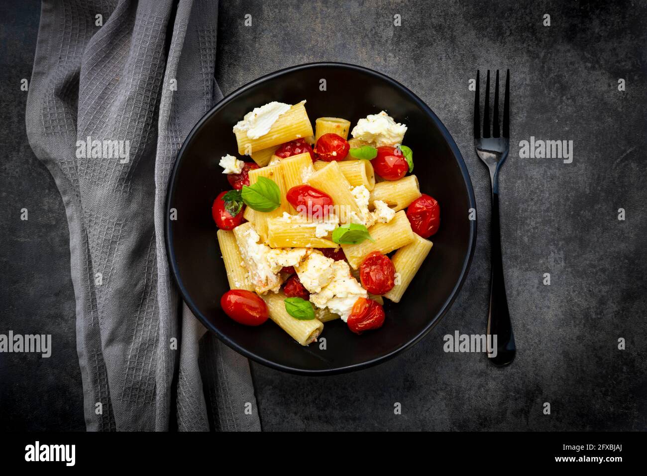 Rigatoni pasta with baked tomatoes, feta and basil Stock Photo