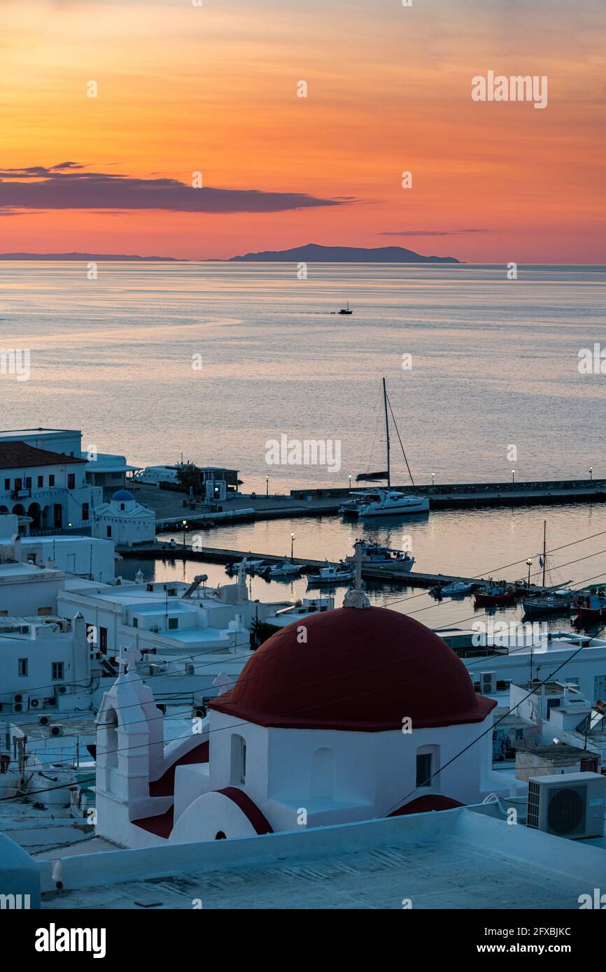 Greece, South Aegean, Horta, Harbor of coastal town at moody dusk with church dome in foreground andÂ Aegean Sea in background Stock Photo