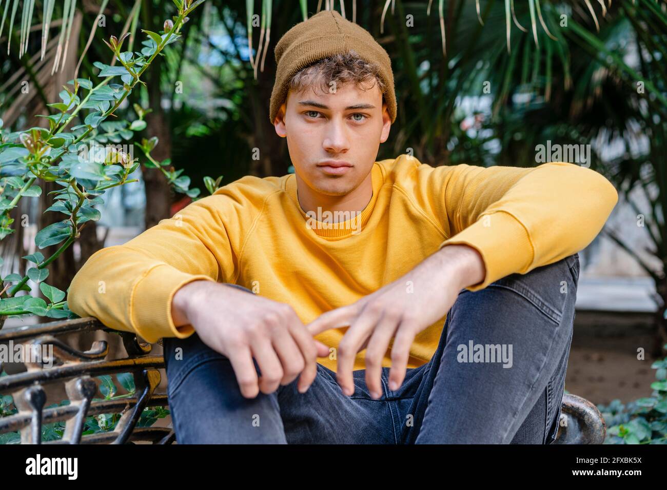 Young man wearing knit hat while sitting at park Stock Photo