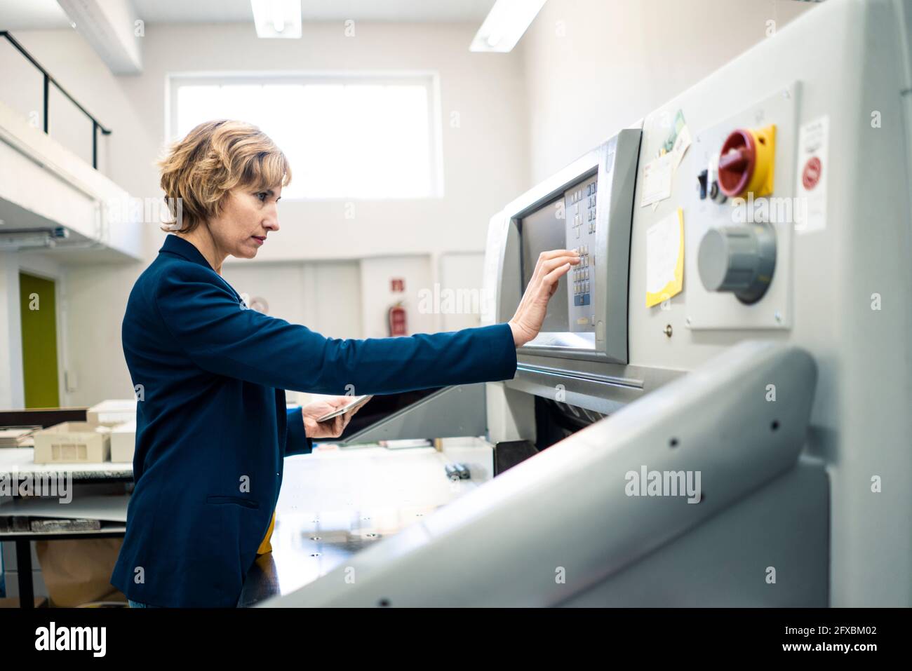 Expertise operating printing machine in workshop Stock Photo