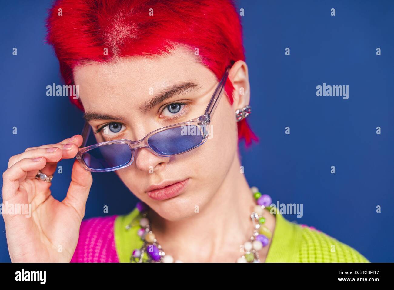 Woman with sunglasses in front of blue background Stock Photo